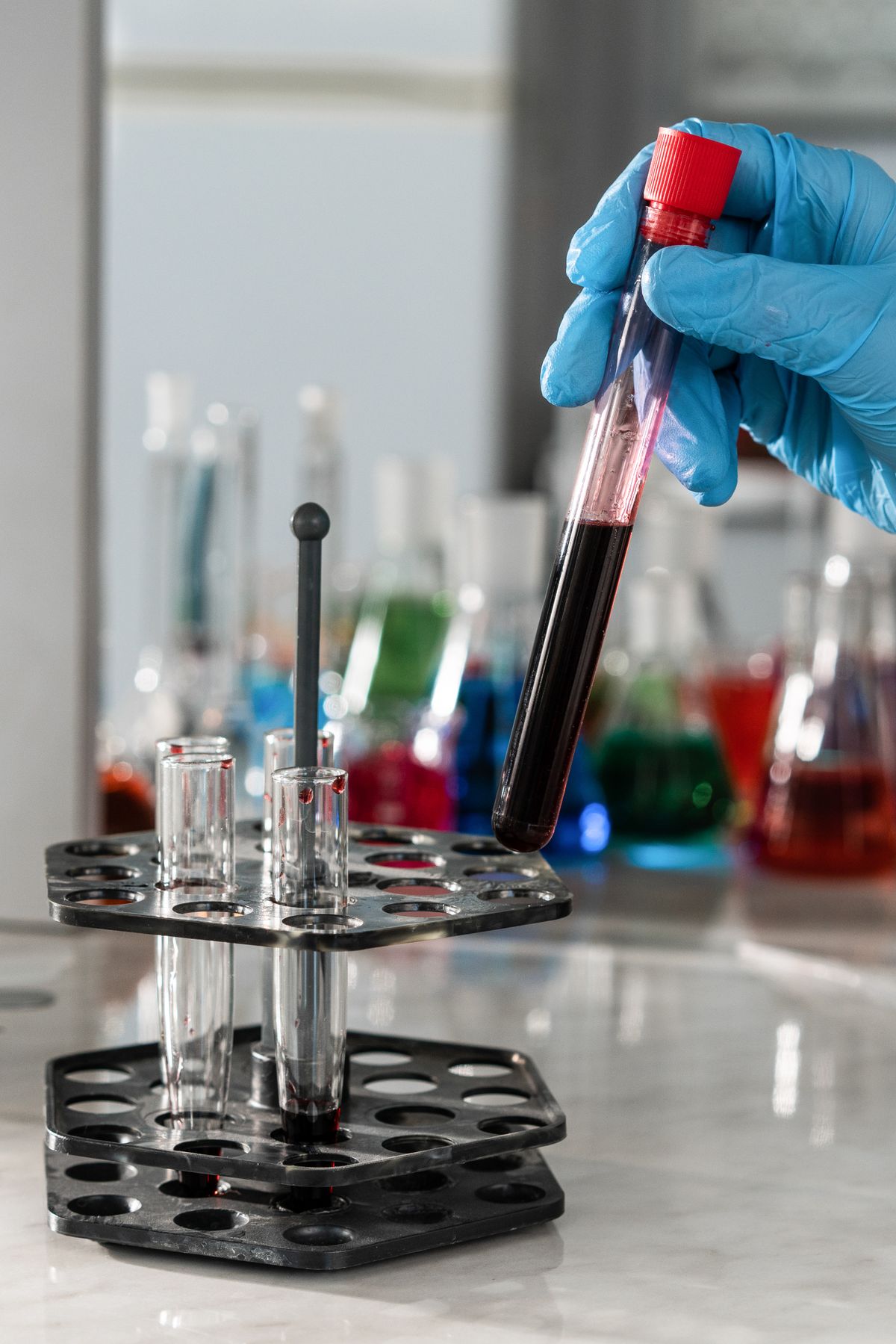 Gloved laboratory professional handling a testing sample