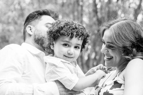 Free Grayscale Photography of Couple Carrying a Cute Toddler Stock Photo