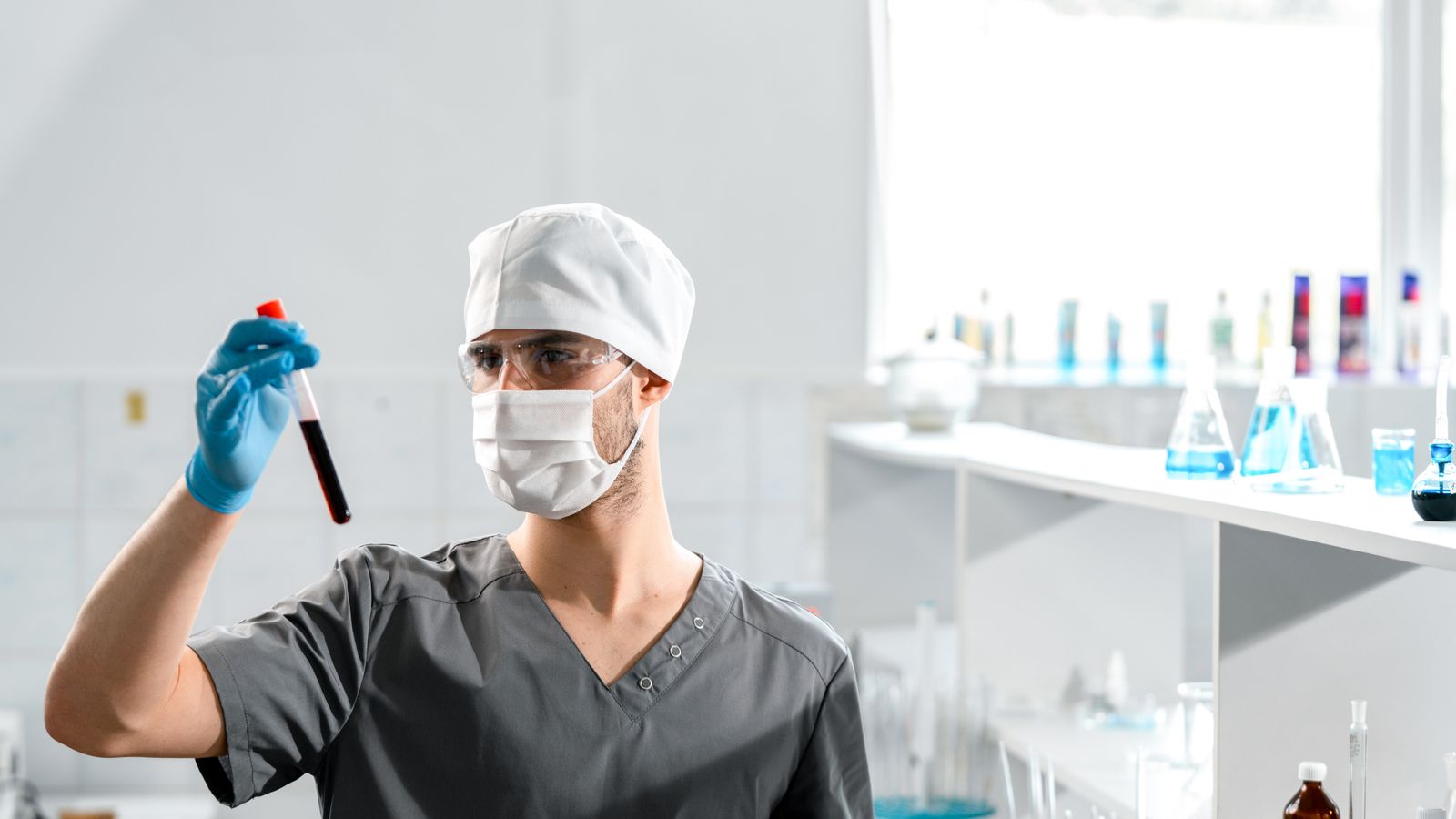 A medical professional analyzing a blood sample in a bright laboratory setting.