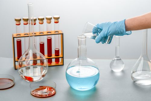 Free Close-up of scientist pouring liquid into a flask in a laboratory setting Stock Photo