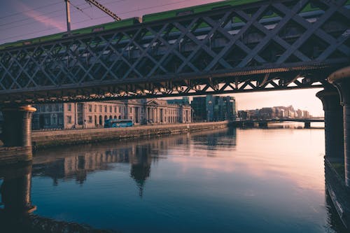 бесплатная Серый металлический мост возле коричневого бетонного здания Стоковое фото