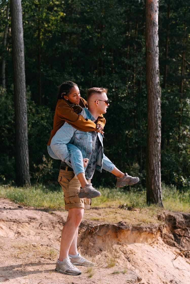 Woman Piggyback Man Walking In Forest