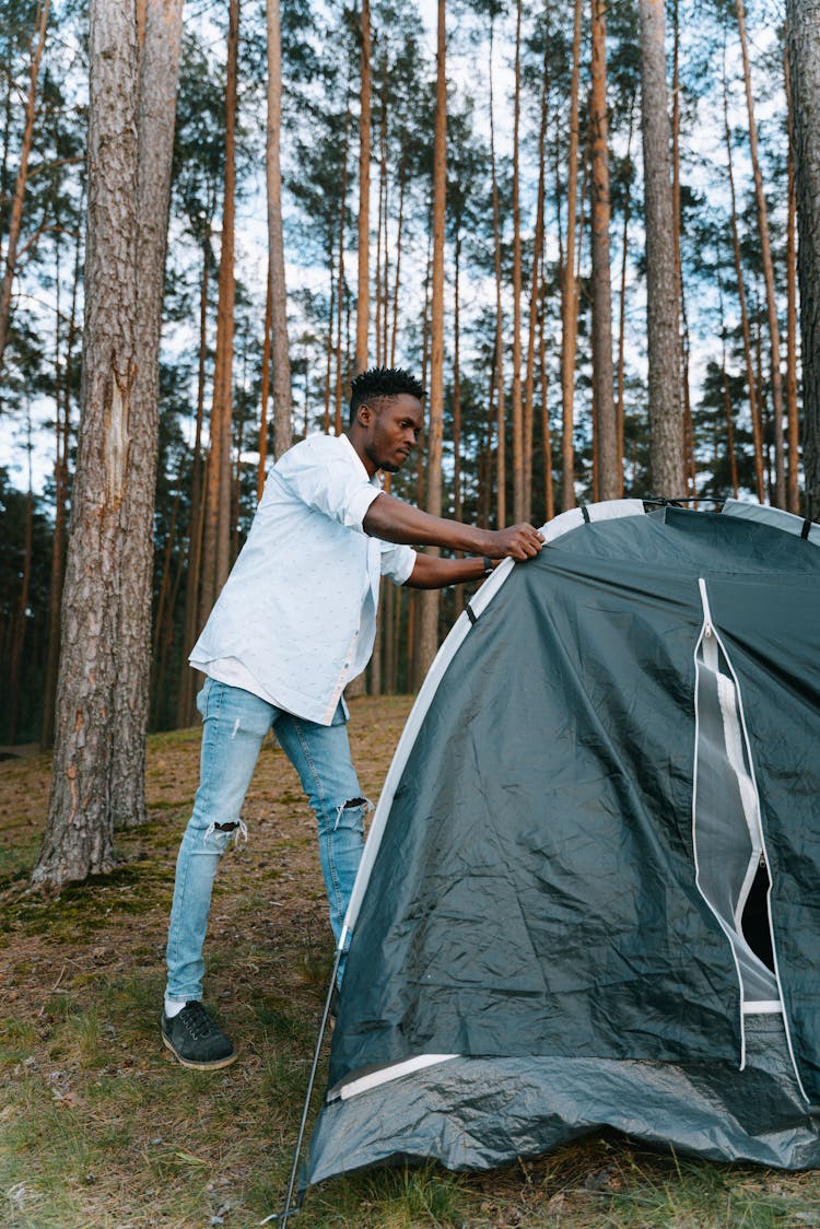 A Man Setting A Tent For Camping