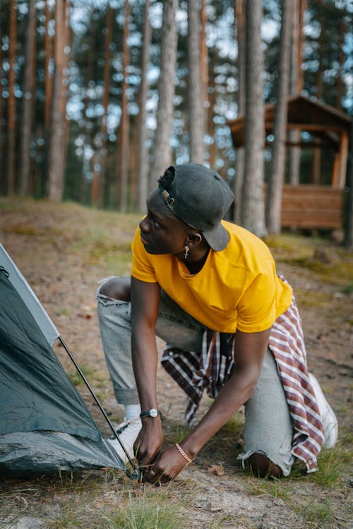 A Man Setting Up a Tent in the Woods