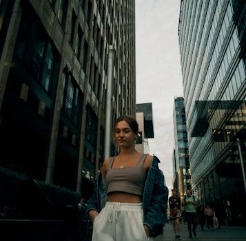 Young woman in casual attire walking through the urban landscape of Moscow cityscape at dusk.