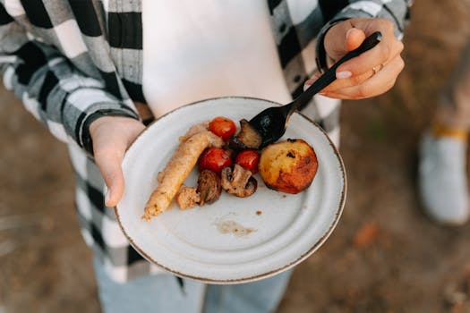 Close-up of grilled sausage and vegetables served on a plate, ideal for food photography.