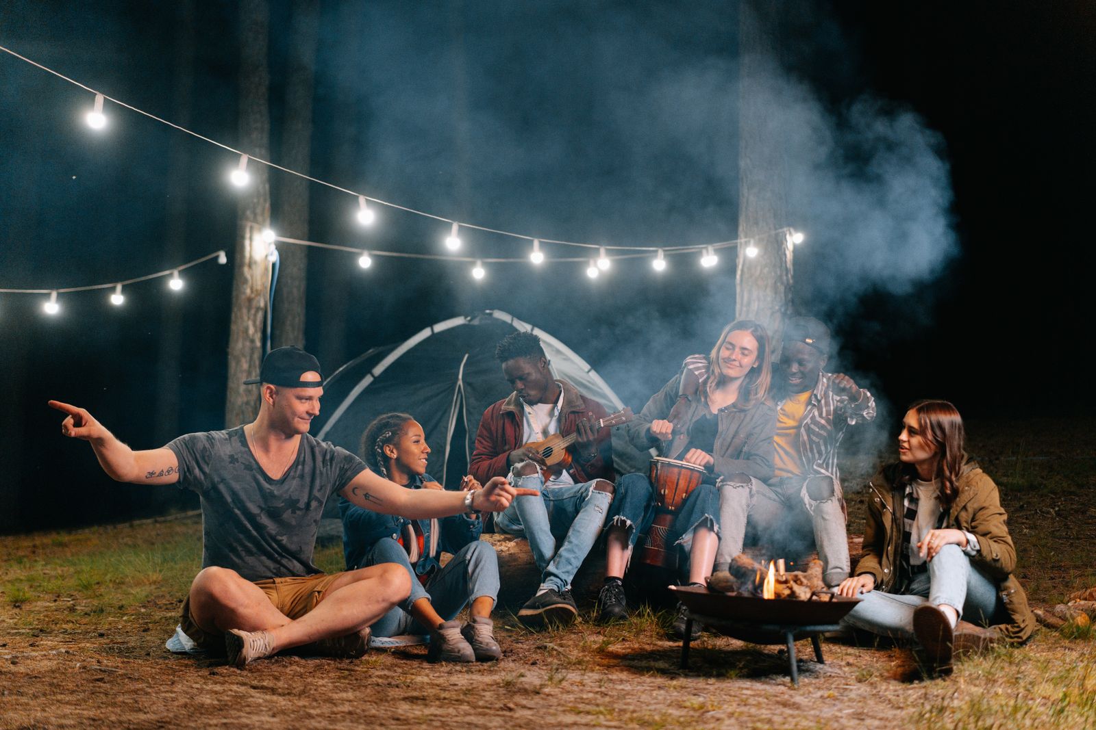 Friends sitting around a campfire in a forest at night