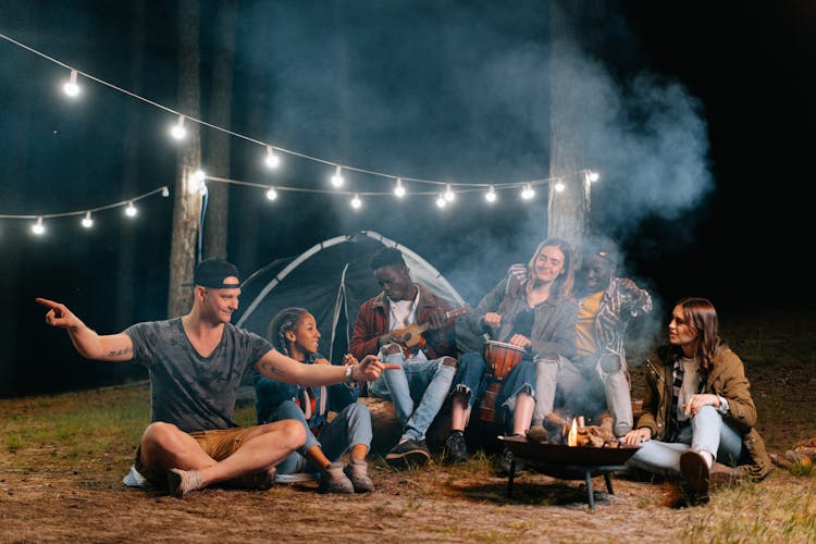 Friends Camping In Forest At Night