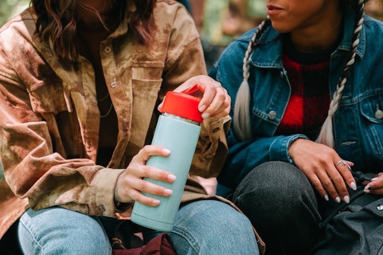 A Person In Brown Jacket Opening The Tumbler He Is Holding