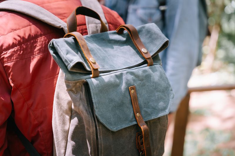 A stylish canvas backpack worn outdoors. Perfect for travel and adventure.