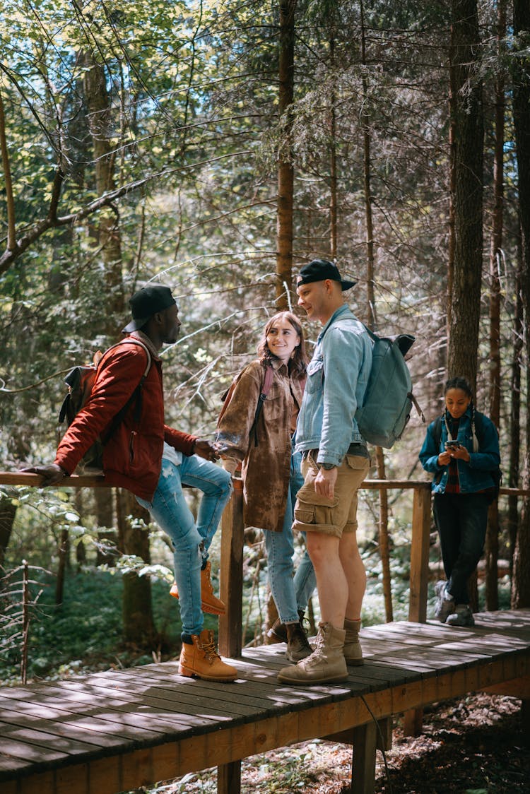 Group Of People Standing On Wooden Bridge