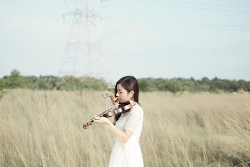 Woman Wearing White Dress Playing Violin