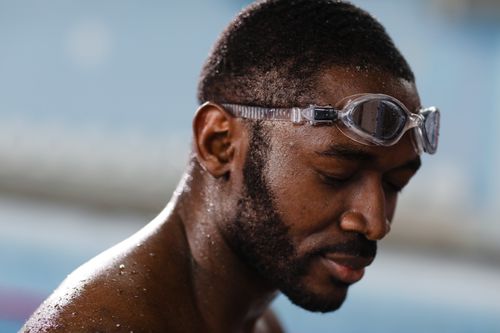 Free Portrait of a focused male swimmer wearing goggles, ready for a swim. Stock Photo