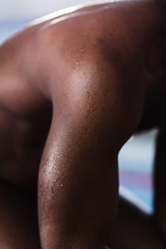 A detailed close-up of a man's wet arm glistening in natural light, showcasing texture and shine.