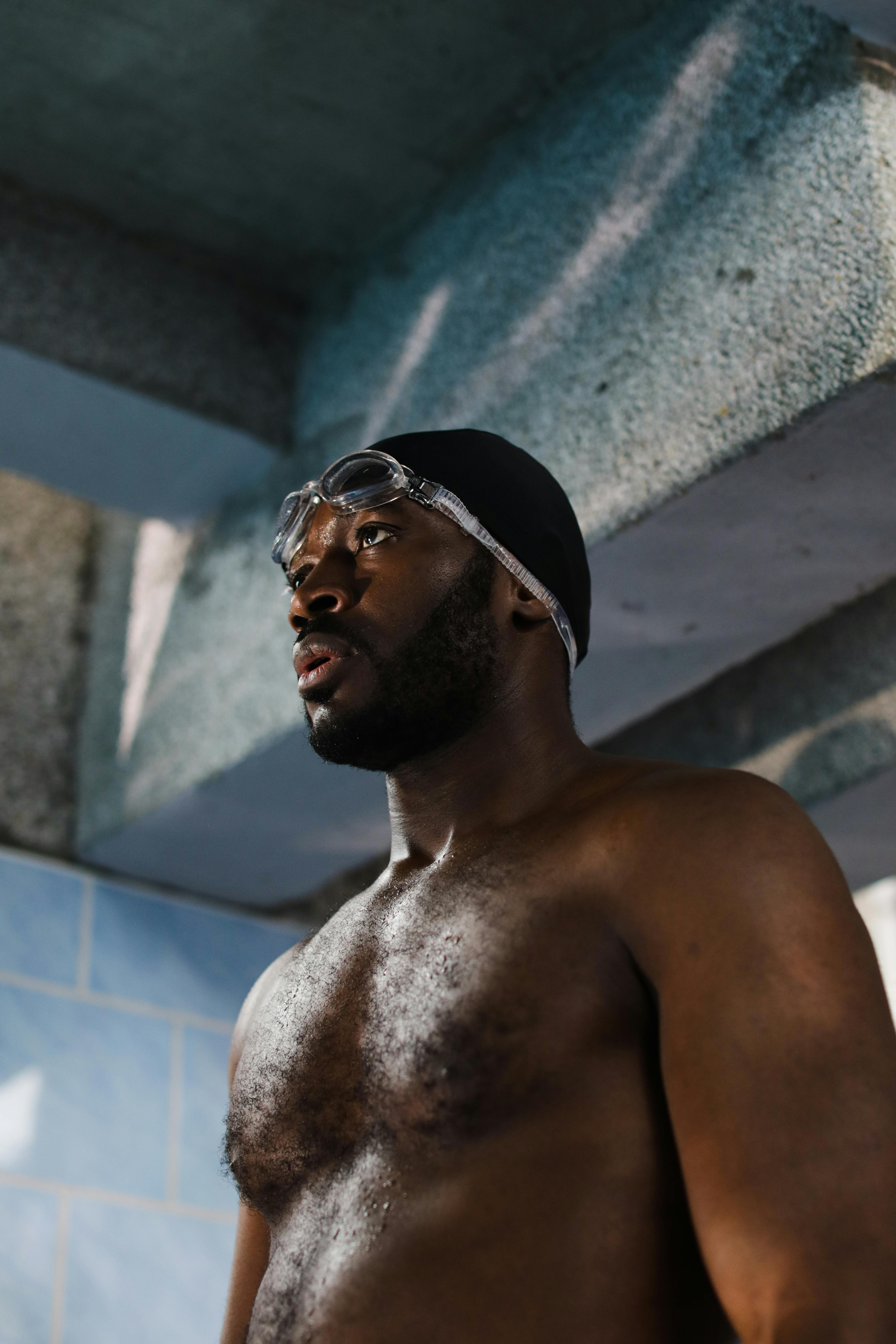 topless man wearing black swimming cap