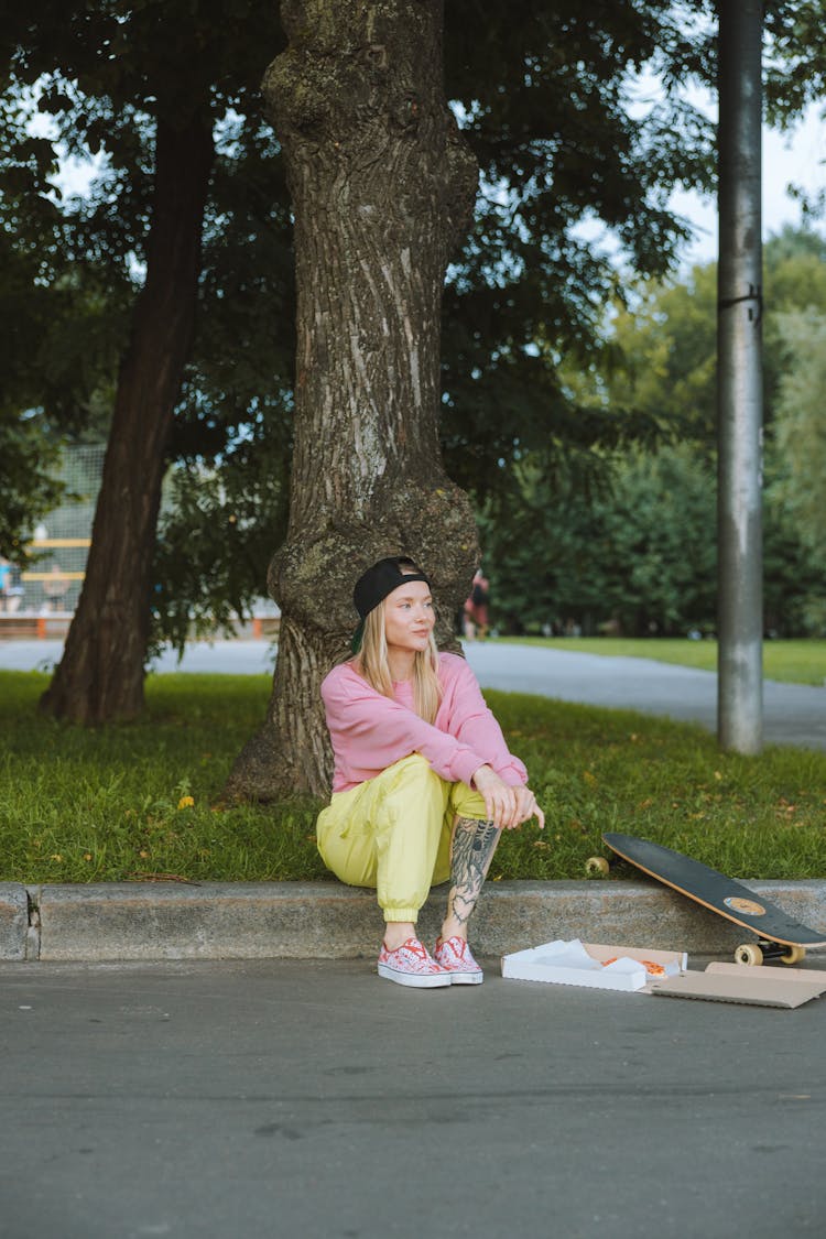 Woman In Pink Sweater Sitting On A Gutter