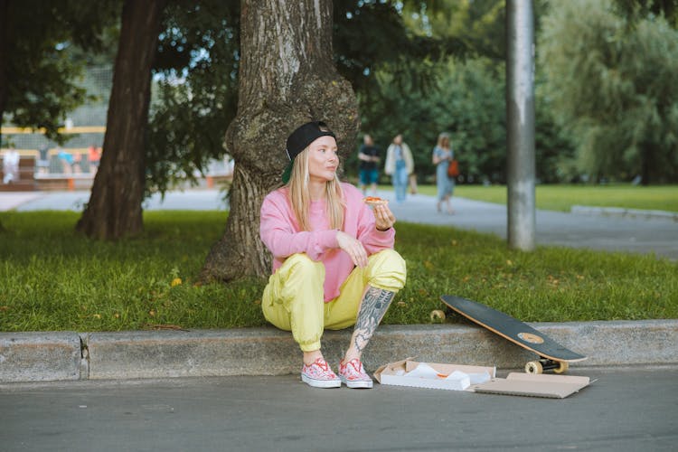 A Skater Eating A Pizza 