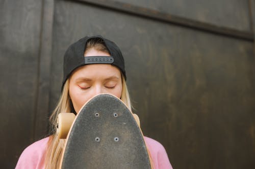 Woman with Eyes Closed Holding a Longboard