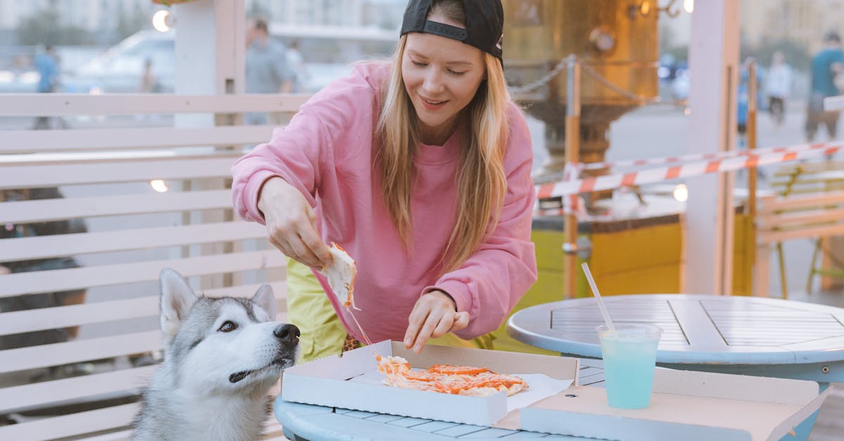 Photo of a Woman Feeding Her Dog Pizza