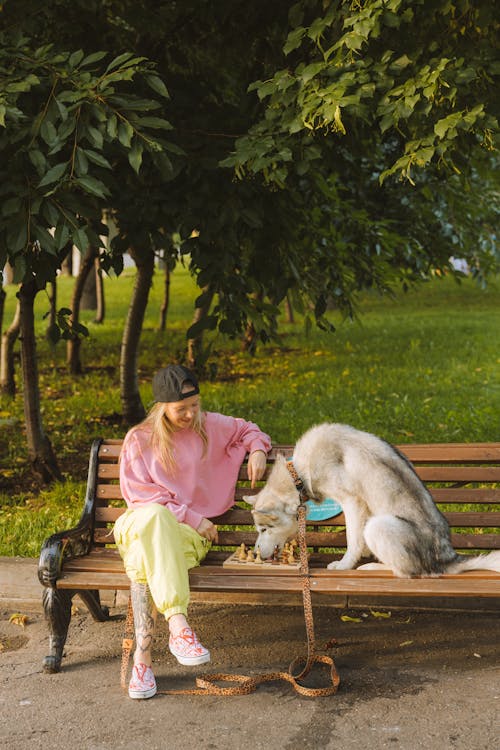 Woman and Her Dog Sitting on a Wooden Bench