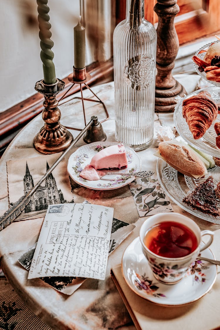 Postcards On A Table With A Cup Of Tea And Delicious Breads And Pie