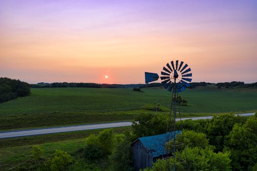 Windmill on Green Grass Field during Sunset