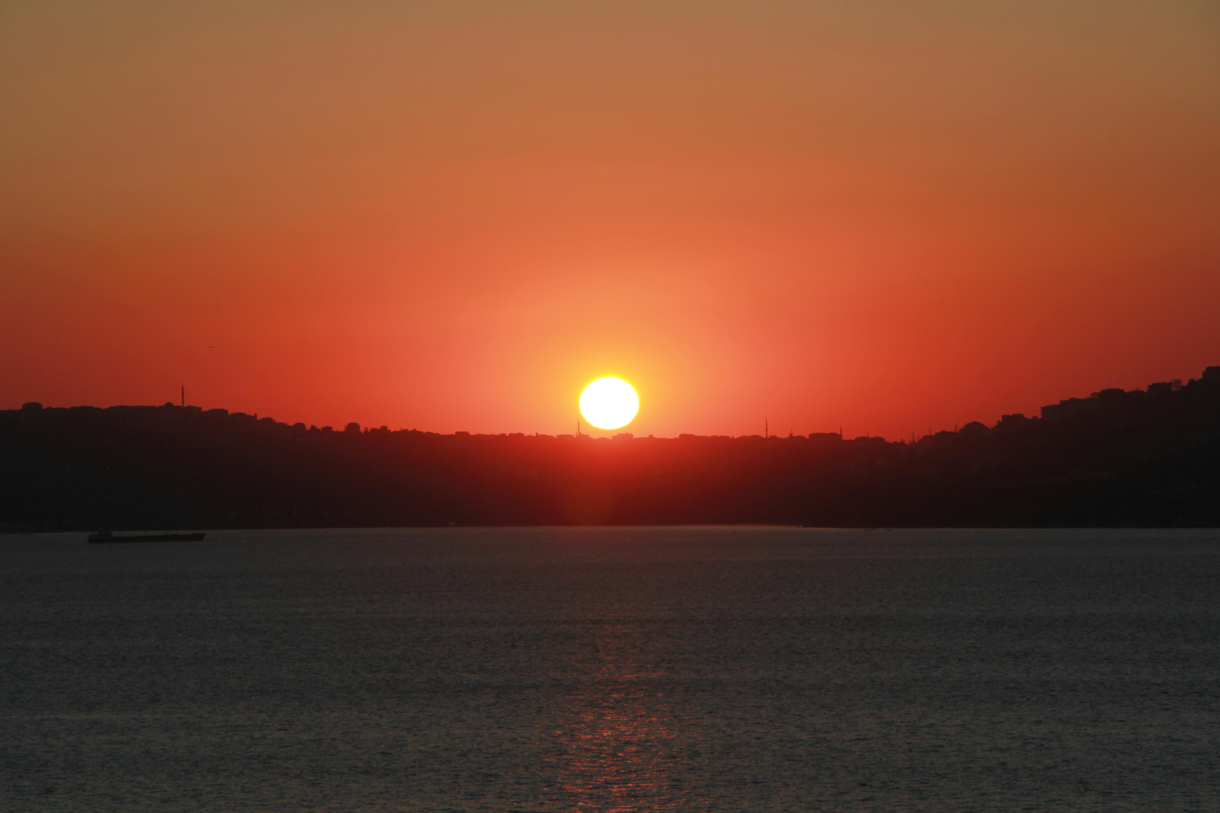 宁静而充满活力的日落，在平静的海平线上映出鲜艳的天空