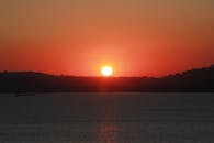 宁静而充满活力的日落，在平静的海平线上映出鲜艳的天空