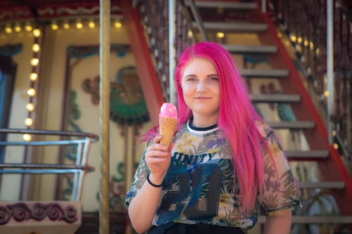 Close-Up Shot of a Woman with Pink Hair Holding an Ice Cream