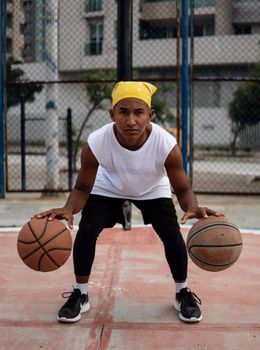 A young man practicing basketball outdoors, showcasing focus and athleticism.