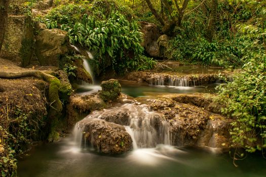 Tranquil waterfall in a lush forest setting, showcasing nature's beauty and serenity.