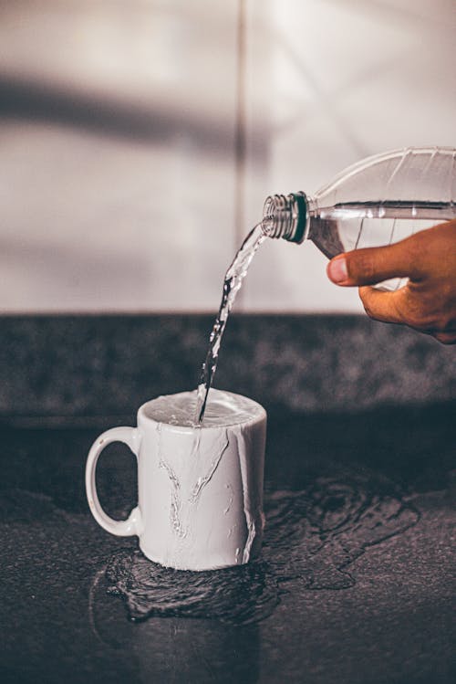 Free Person Pouring Water on White Ceramic Mug Stock Photo