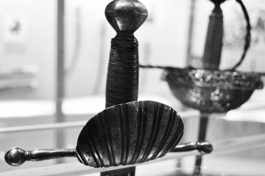 Detailed close-up of a vintage sword hilt in black and white, showcasing texture.