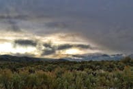 山峦上雾气缭绕，日落天空的景色十分壮观