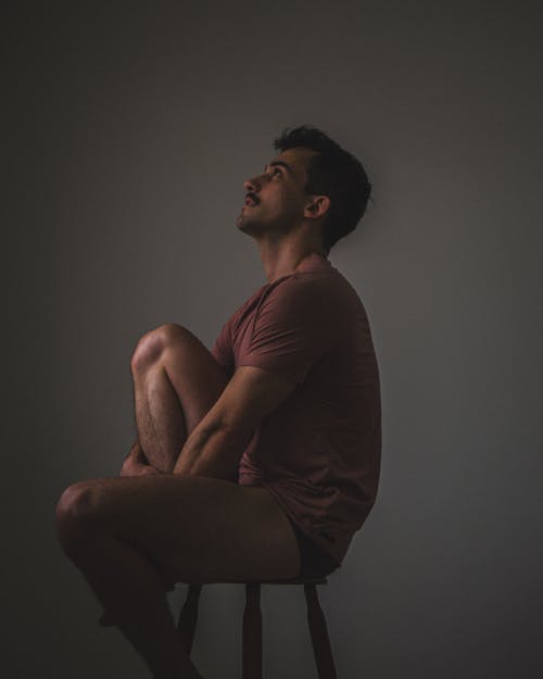 Free Man looking up sitting on a Wooden Stool  Stock Photo