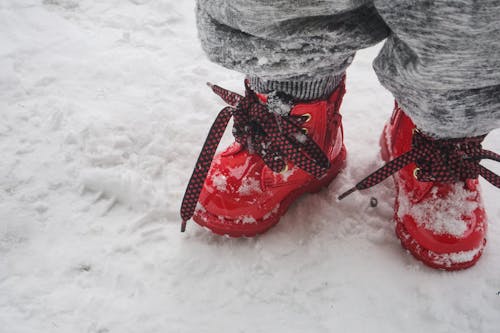 gratis Peuter Die Rode Schoenen Draagt Die Zich Op Sneeuw Bevinden Stockfoto