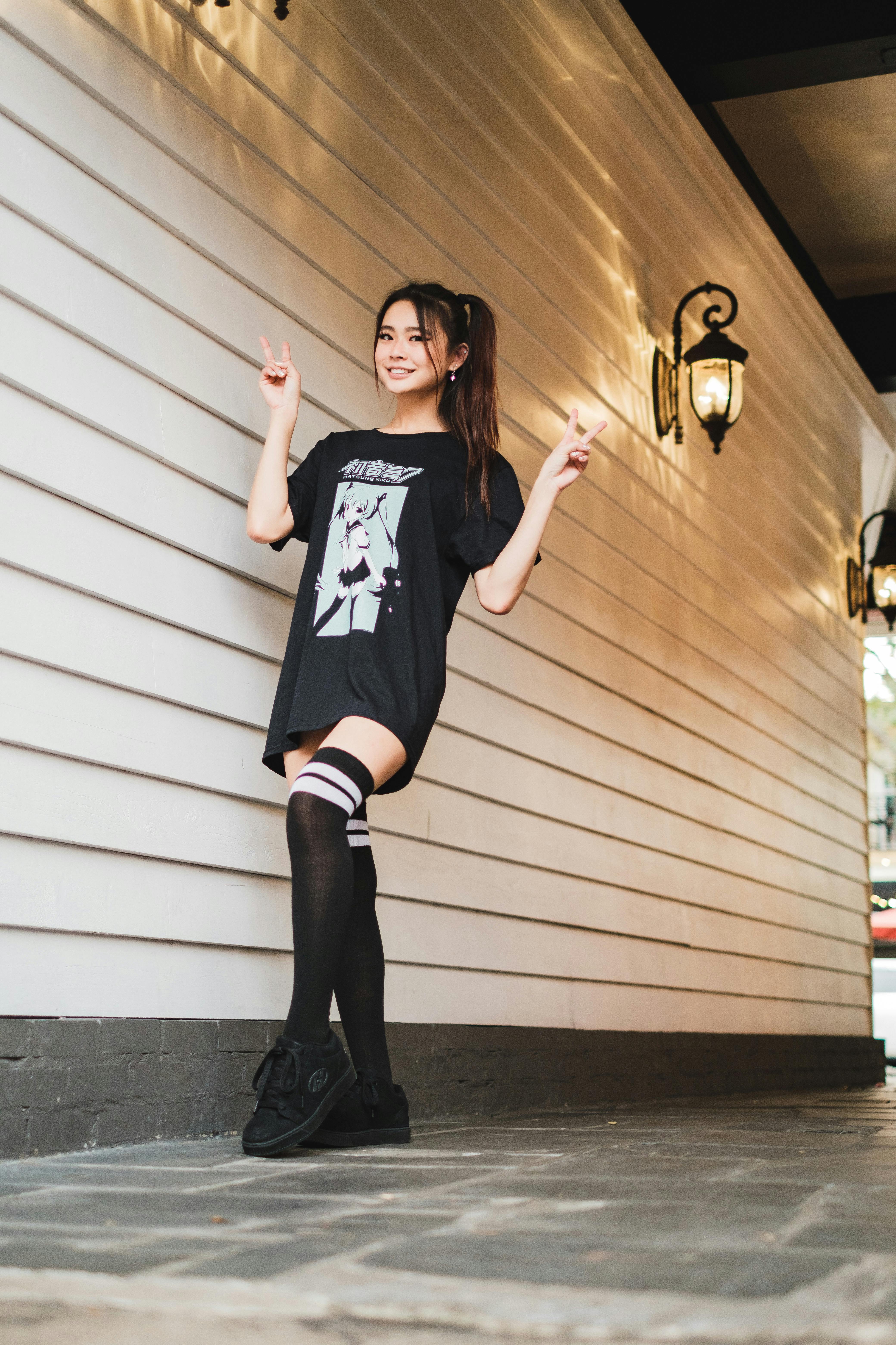 Woman in Black Oversized Shirt Holding a Brown Wooden Frame Free