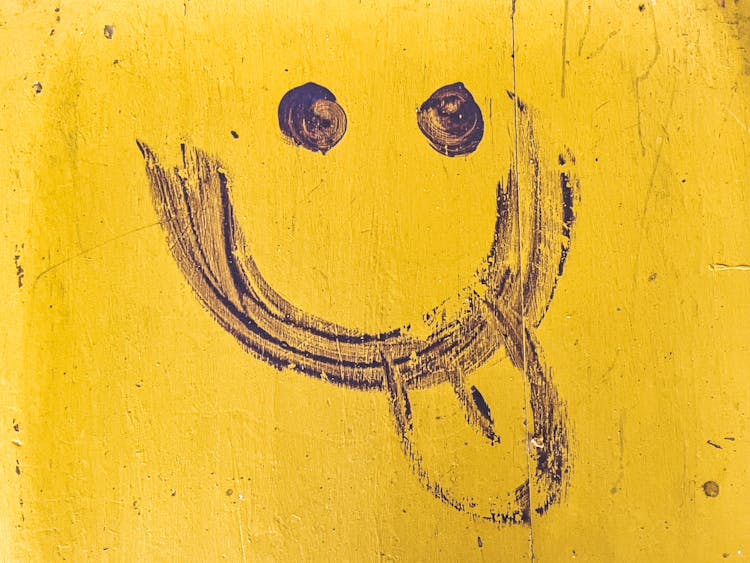 Drawing Of A Face With Tongue Out On A Yellow Wall