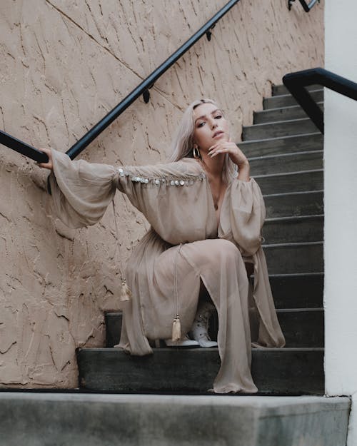 Alluring Woman in a Sheer Dress sitting in a Concrete Staircase