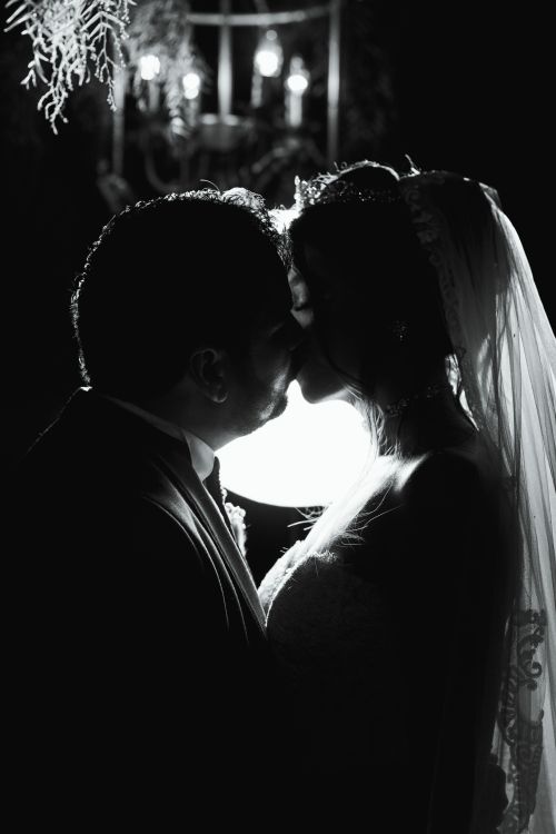 Free Silhouette of a couple kissing in a romantic black and white wedding scene. Stock Photo
