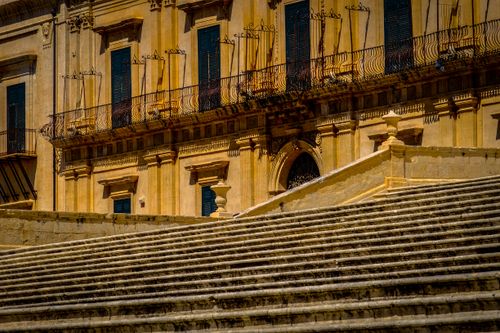 Free Elegant historic building facade with stone steps under bright sunlight, featuring intricate architectural details. Stock Photo