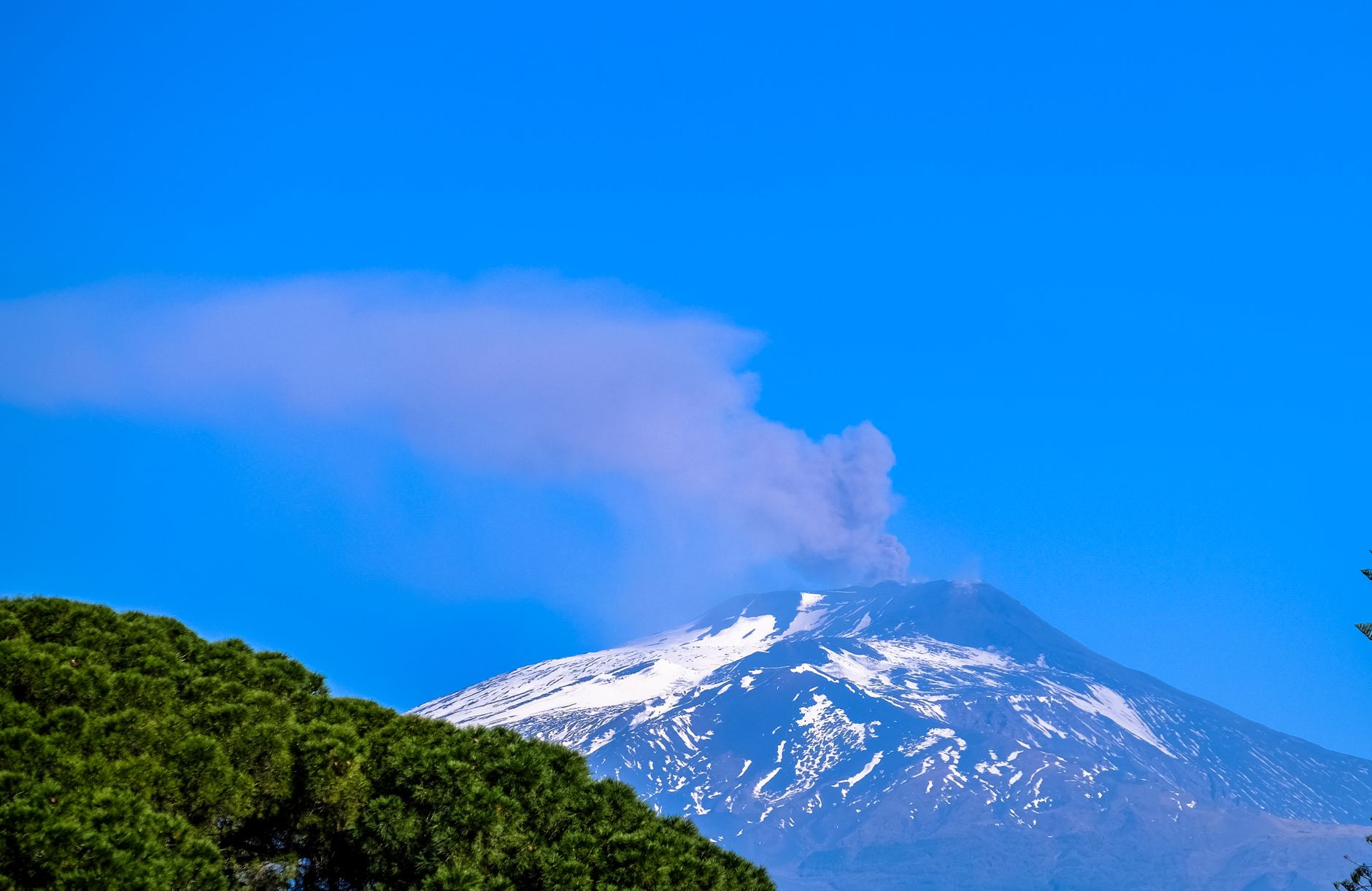 Une vue générale d'un volcan en activité projetant des panaches de fumée dans le ciel.