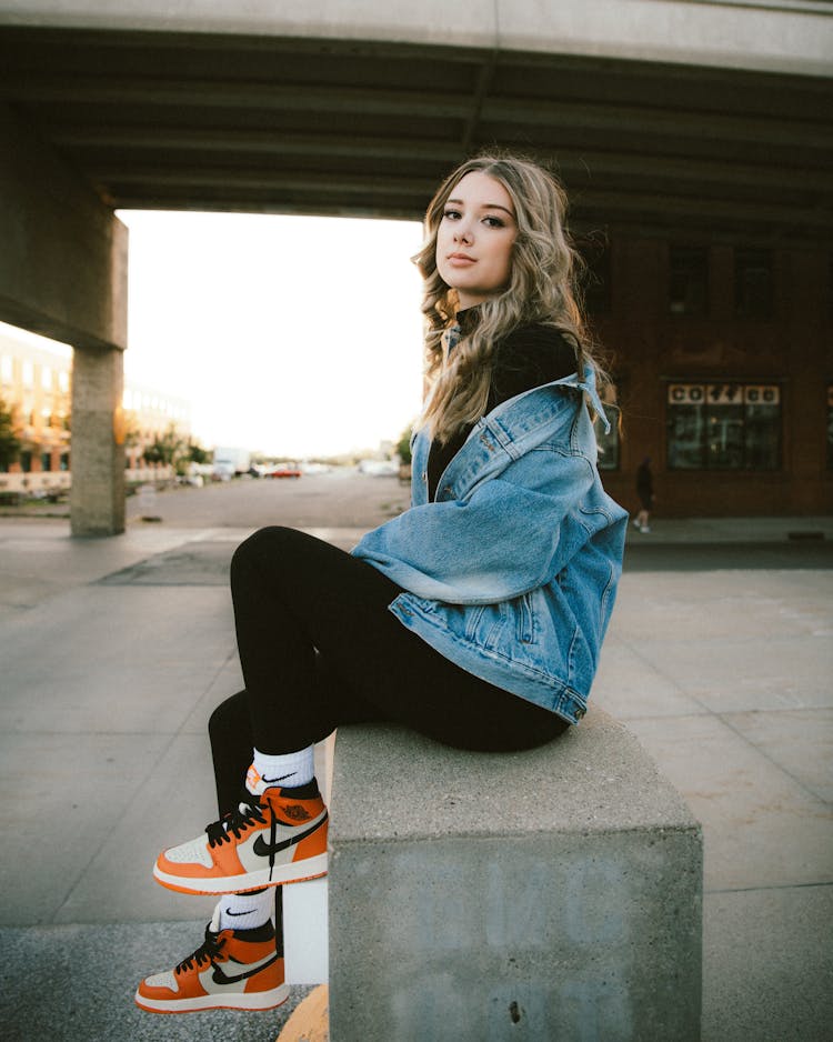 Side View Of Sitting Woman In Denim Jacket