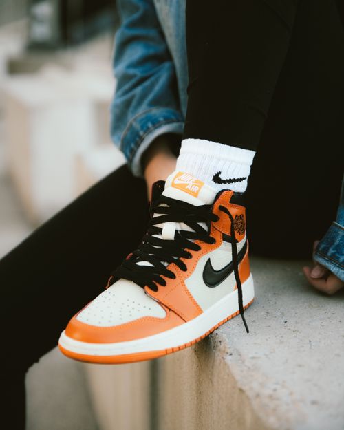 Free Close-up of stylish orange sneakers and denim jacket, capturing modern street fashion. Stock Photo