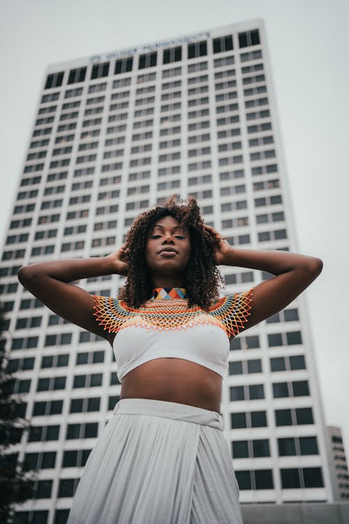 Young African-American woman standing in front of skyscraper