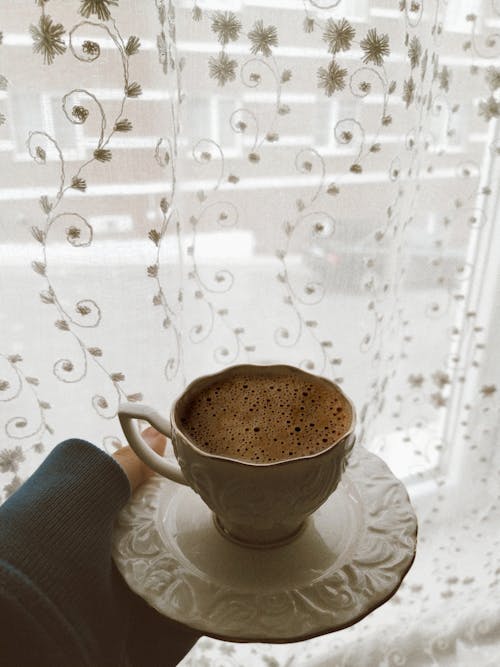 Holding a Saucer with a Cup of Coffee