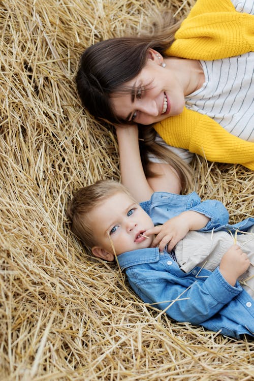 Free Woman in Yellow Shirt and Blue Denim Jeans Carrying Girl in Yellow Shirt Stock Photo