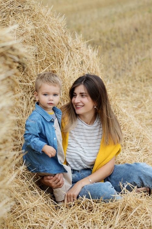 Free Mother and Child Sitting on Haystack Stock Photo
