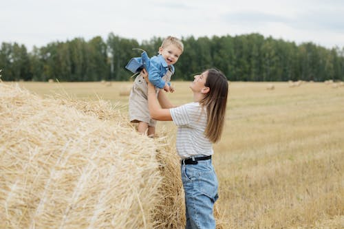 Free A Woman Carrying a Boy in the Farmland Stock Photo