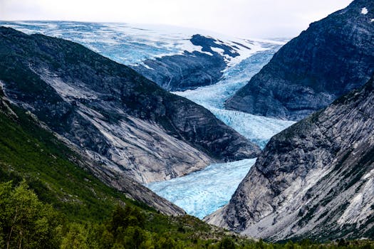 Explore the majestic Nigardsbreen Glacier as it flows through the dramatic mountain landscape in Luster, Norway.